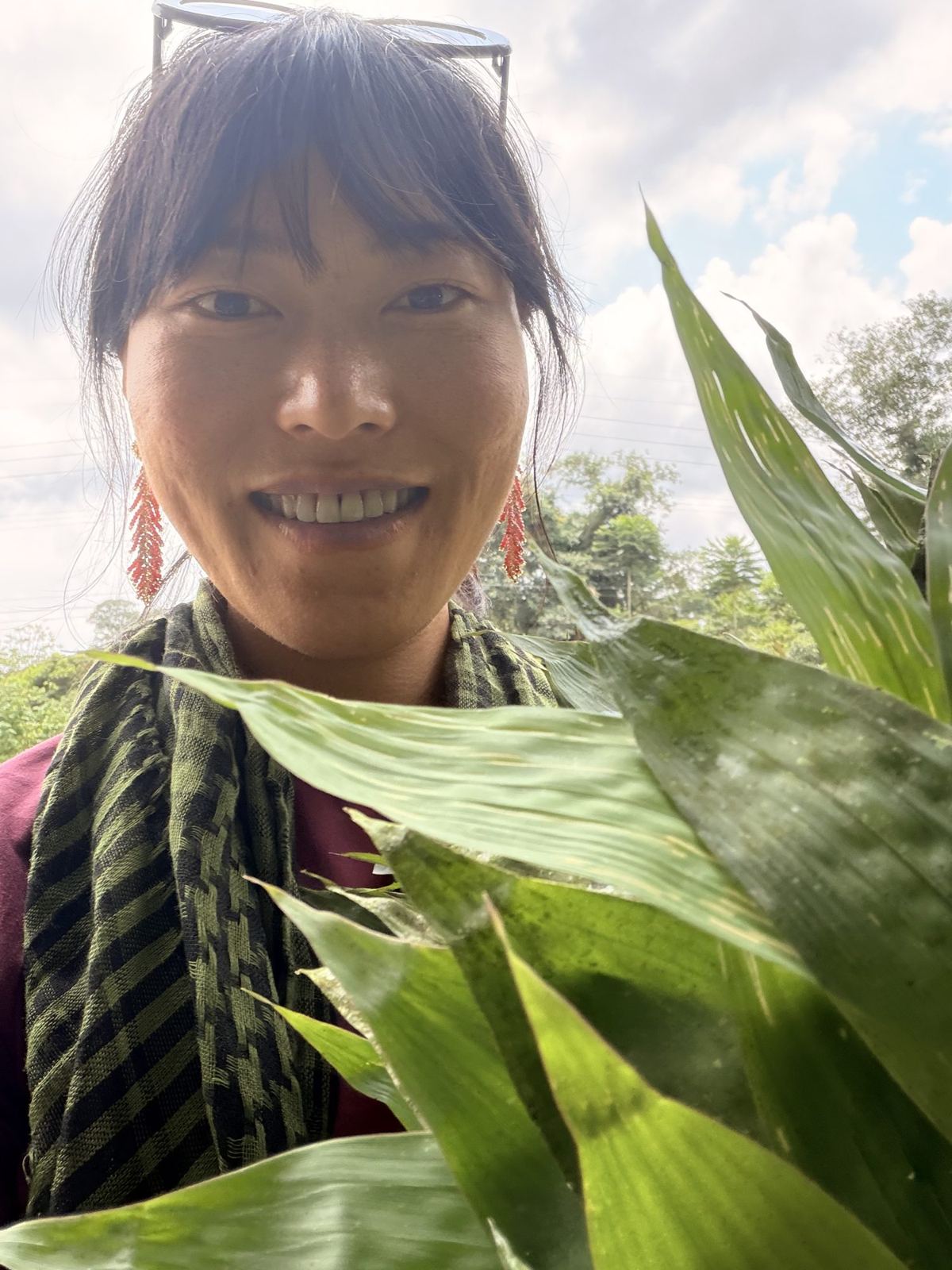 Min smiling between big green leaves