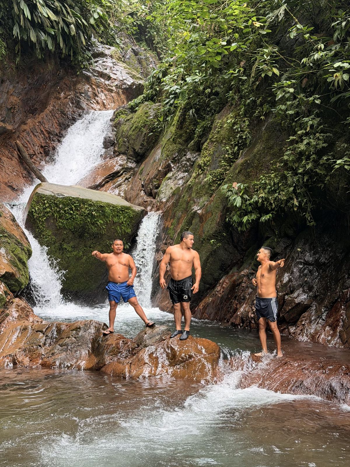 Guests standing under a jungle waterfall